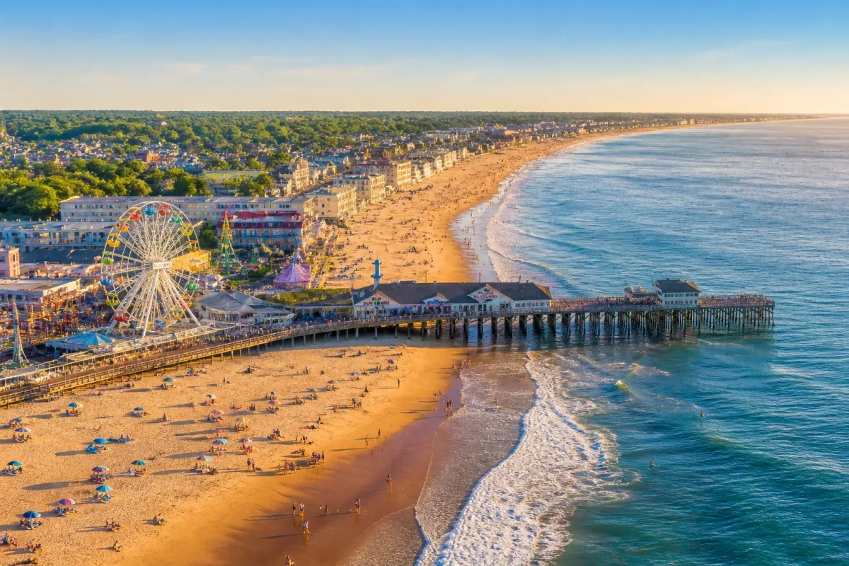 Aerial summer view of Old Orchard Beach Maine showing the sandy shoreline, Palace Playland Ferris wheel, and historic wooden pier extending into the Atlantic Ocean